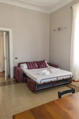 a bed sitting in a room with a couch at èROMA - ESQUILINO Apartment in Rome