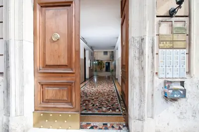 an empty hallway with a wooden door and a tile floor at Residenza Laterano in Rome