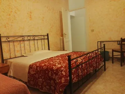 a bedroom with a bed with a red comforter at Residenza Laterano in Rome