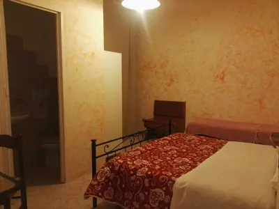 a bedroom with a bed and a bathroom with a toilet at Residenza Laterano in Rome