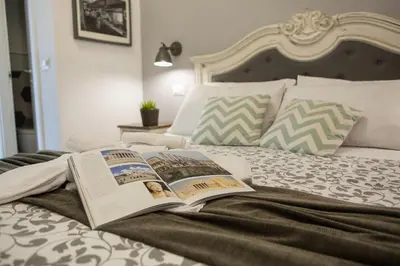 a bed with two open books on top of it at Maison Coquette in Rome