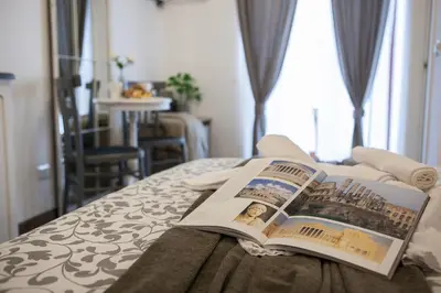 a book sitting on top of a bed at Maison Coquette in Rome