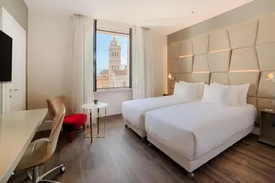 a hotel room with a large bed and a window at NH Collection Palazzo Cinquecento in Rome