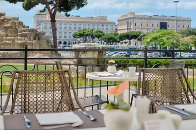 a table with two chairs and a table with a cup of coffee at NH Collection Palazzo Cinquecento in Rome