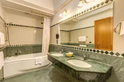 a bathroom with two sinks and a tub and a mirror at Hotel Contilia in Rome