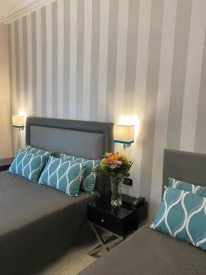 a bedroom with a bed with a vase of flowers on a table at Hotel Contilia in Rome