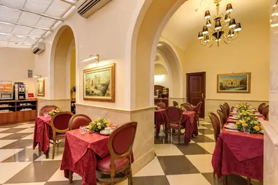 a restaurant with tables and chairs and a chandelier at Hotel Contilia in Rome