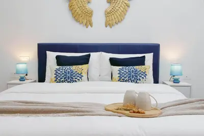 a bed with a blue headboard with a tray of food on it at Ricky Bijoux by DomusDimore in Rome