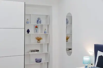 a white book shelf in a living room at Ricky Bijoux by DomusDimore in Rome