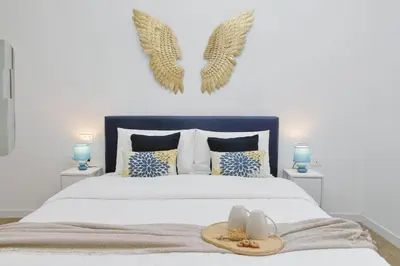 a bedroom with a bed with angel wings on the wall at Ricky Bijoux by DomusDimore in Rome