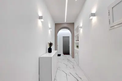 a hallway with white walls and marble flooring at Ricky Bijoux by DomusDimore in Rome