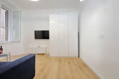 a living room with a blue couch and a white wall at 4BNB - Marmorata Urban Nest in Rome