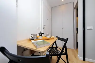 a dining room with a wooden table and two chairs at 4BNB - Marmorata Urban Nest in Rome