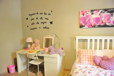 a bedroom with a bed and a desk with stuffed animals at Alexia Home in Rome