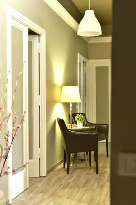a living room with a desk and a chair and a lamp at Alexia Home in Rome