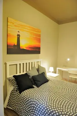 a bedroom with a bed with a lighthouse painting on the wall at Alexia Home in Rome
