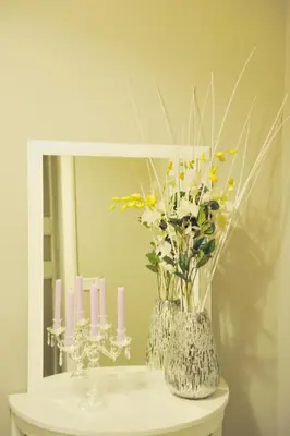 two vases with flowers and candles on a table in front of a mirror at Alexia Home in Rome