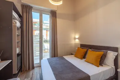 a bedroom with a bed with yellow pillows and a window at Residenza Cavallini in Rome