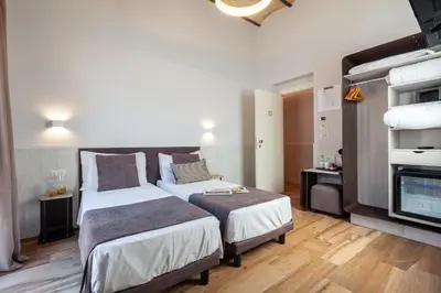 a hotel room with two beds and a tv at Residenza Cavallini in Rome