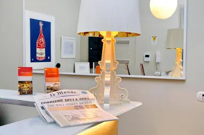 a lamp sitting on top of a table with a newspaper at Relais Servio Tullio in Rome