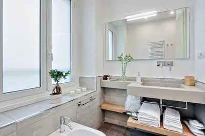 a white bathroom with a sink and a mirror at Relais Servio Tullio in Rome
