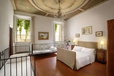 a bedroom with a bed and a chandelier at The Right Place 4U Quercia Apartment in Rome