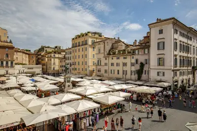a crowd of people walking around a market with white umbrellas at The Right Place 4U Quercia Apartment in Rome