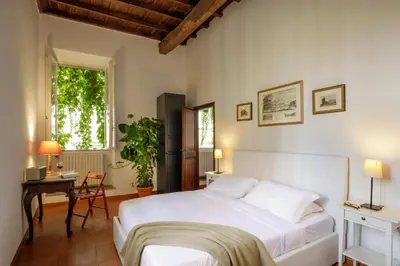 a bedroom with a bed and a table and a window at The Right Place 4U Quercia Apartment in Rome