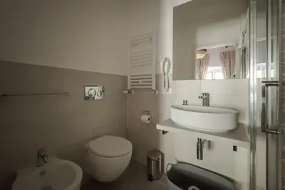 a white bathroom with a sink and a toilet at White Ostilia Guesthouse in Rome