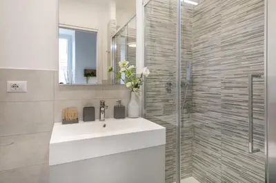 a bathroom with a sink and a glass shower at White Ostilia Guesthouse in Rome