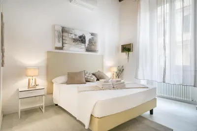 a white bedroom with a bed and a window at White Ostilia Guesthouse in Rome