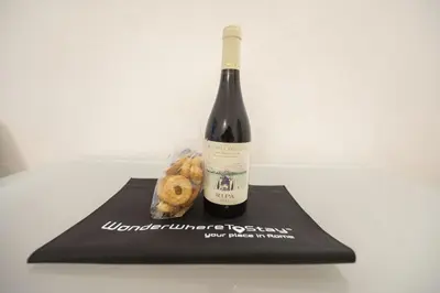 a bottle of wine and some donuts on a napkin at Grotto Apartment by Campo de Fiori in Rome