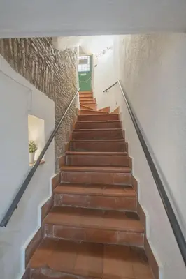 a staircase with a green door in a building at Grotto Apartment by Campo de Fiori in Rome