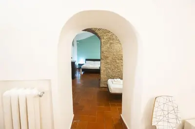 a hallway with an archway and a room with a bed at Grotto Apartment by Campo de Fiori in Rome