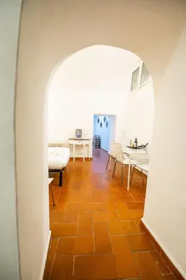 a hallway with an archway with a dining room and a table at Grotto Apartment by Campo de Fiori in Rome