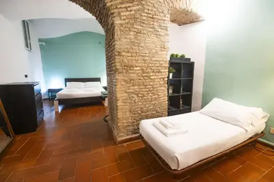 a room with two beds and a brick wall at Grotto Apartment by Campo de Fiori in Rome