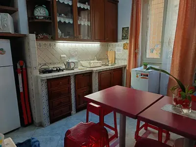 a kitchen with a red table and a table and a refrigerator at Casavamica in Rome