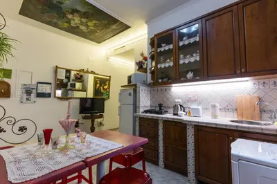 a kitchen with wooden cabinets and a table with chairs at Casavamica in Rome