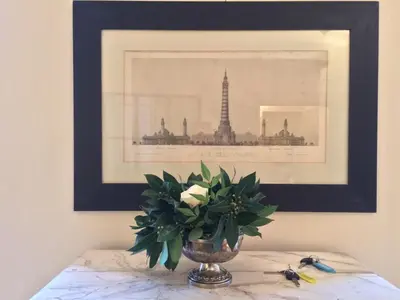 a vase of flowers on a table with a picture at La Casa In Vetrina in Rome