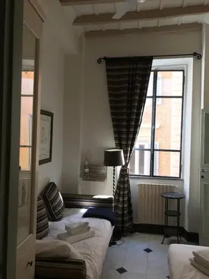 a bedroom with two beds and a large window at La Casa In Vetrina in Rome