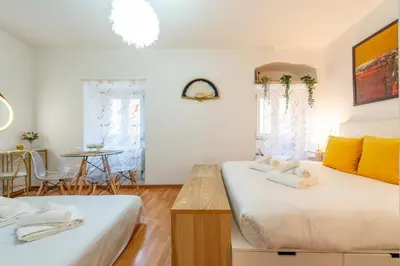 two beds in a room with a table and chairs at Shalimar House Navona by Ghor in Rome
