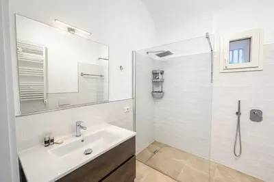 a white bathroom with a sink and a shower at Studio Coppelle in Rome