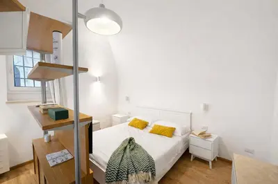 a small bedroom with a bed with yellow pillows at Studio Coppelle in Rome