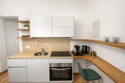 a kitchen with white cabinets and a sink at Studio Coppelle in Rome
