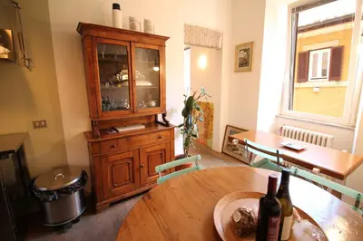 a dining room with a wooden table and a cabinet at The Trevi Fountain and Spanish Steps Experience in Rome