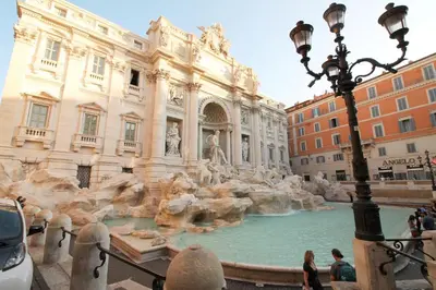 a fountain in a building with people standing around it at The Trevi Fountain and Spanish Steps Experience in Rome