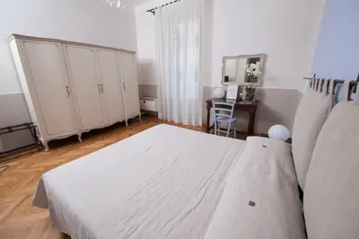a white bedroom with a bed and a desk at Florian Rooms Guest House in Rome