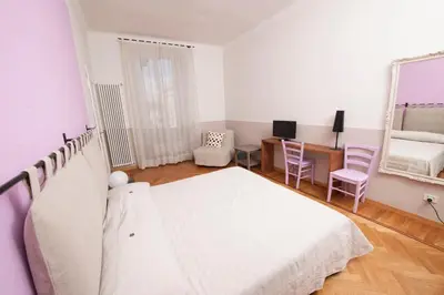 a bedroom with a bed and a desk and a mirror at Florian Rooms Guest House in Rome