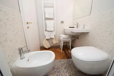 a bathroom with a white toilet and a sink at Florian Rooms Guest House in Rome