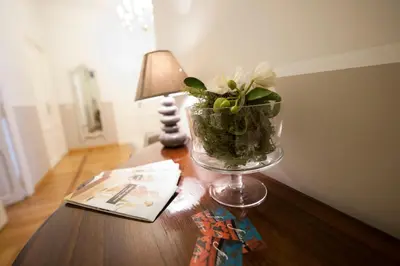 a vase of flowers on a table with a lamp at Florian Rooms Guest House in Rome